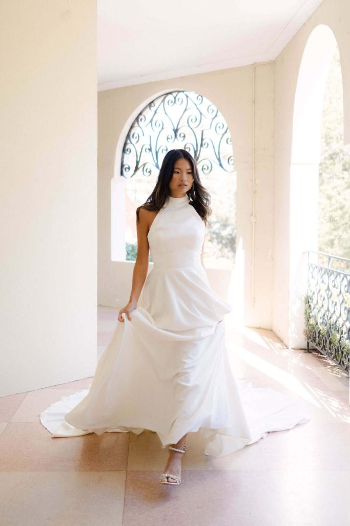 Halter-neck satin A-line wedding gown with a long flowing train by Cizzy Bridal