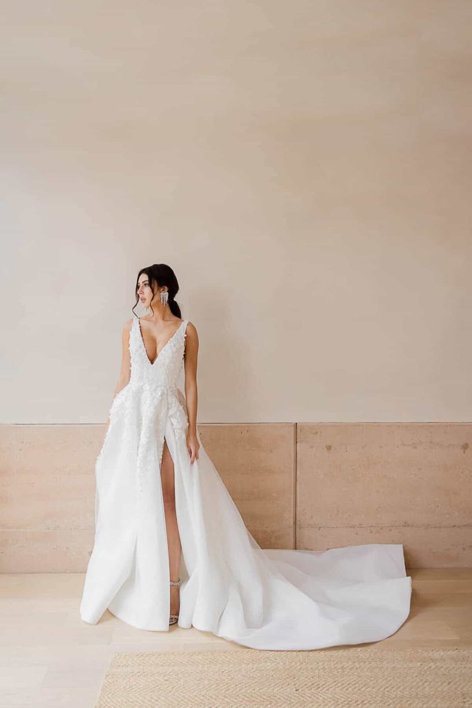Plunging V-neck floral appliqué A-line gown with thigh slit by Elysian Bridal