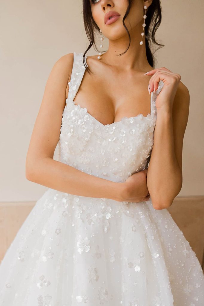 Square-neck bodice with 3D sequin flowers and sparkling tulle skirt, close-up