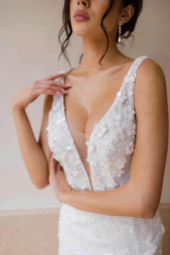 Plunging V-neck bodice with 3D sequin flowers up close by Elysian Bridal