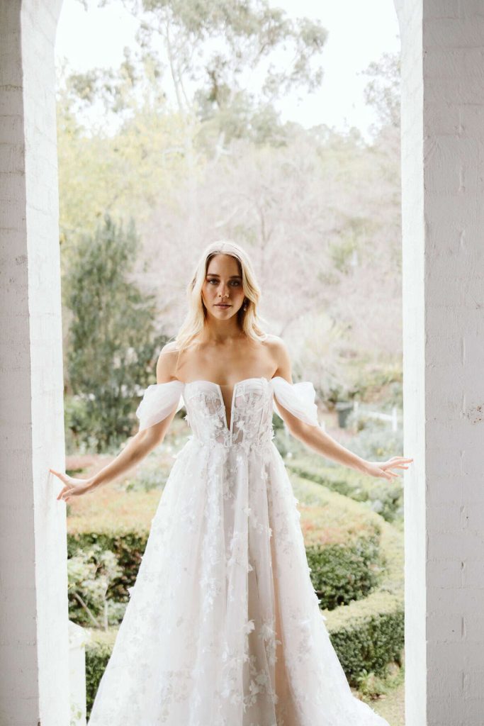 Off-the-shoulder plunging floral appliqué A-line gown by Wedding Societe