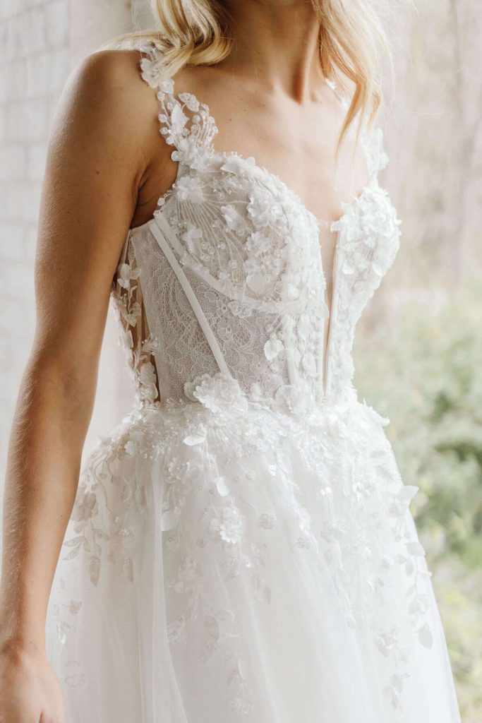 Floral appliqué corset A-line wedding gown with lace straps by Wedding Societe