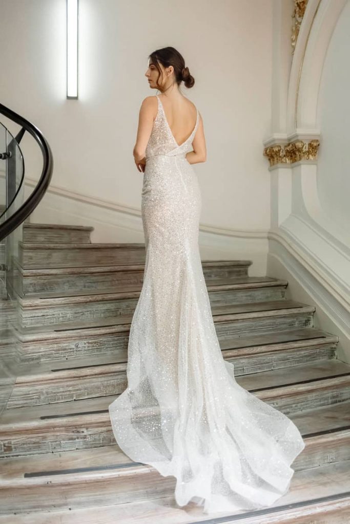 Low V-back sparkling sequin wedding gown with long train by Zavana Bridal