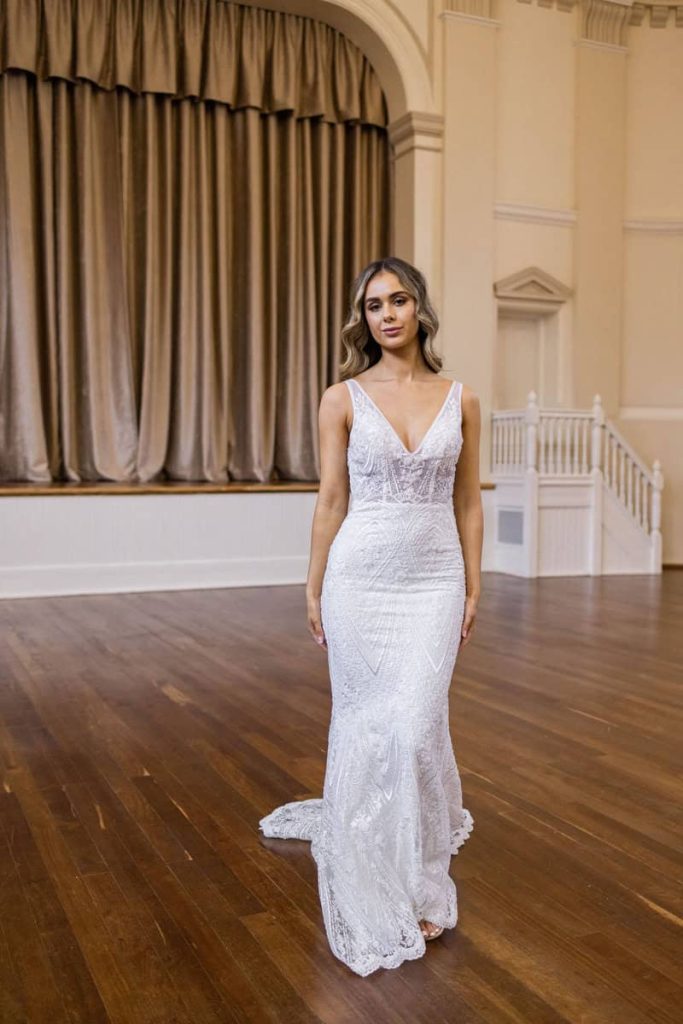V-neck beaded lace sheath wedding gown with train by Zavana Bridal