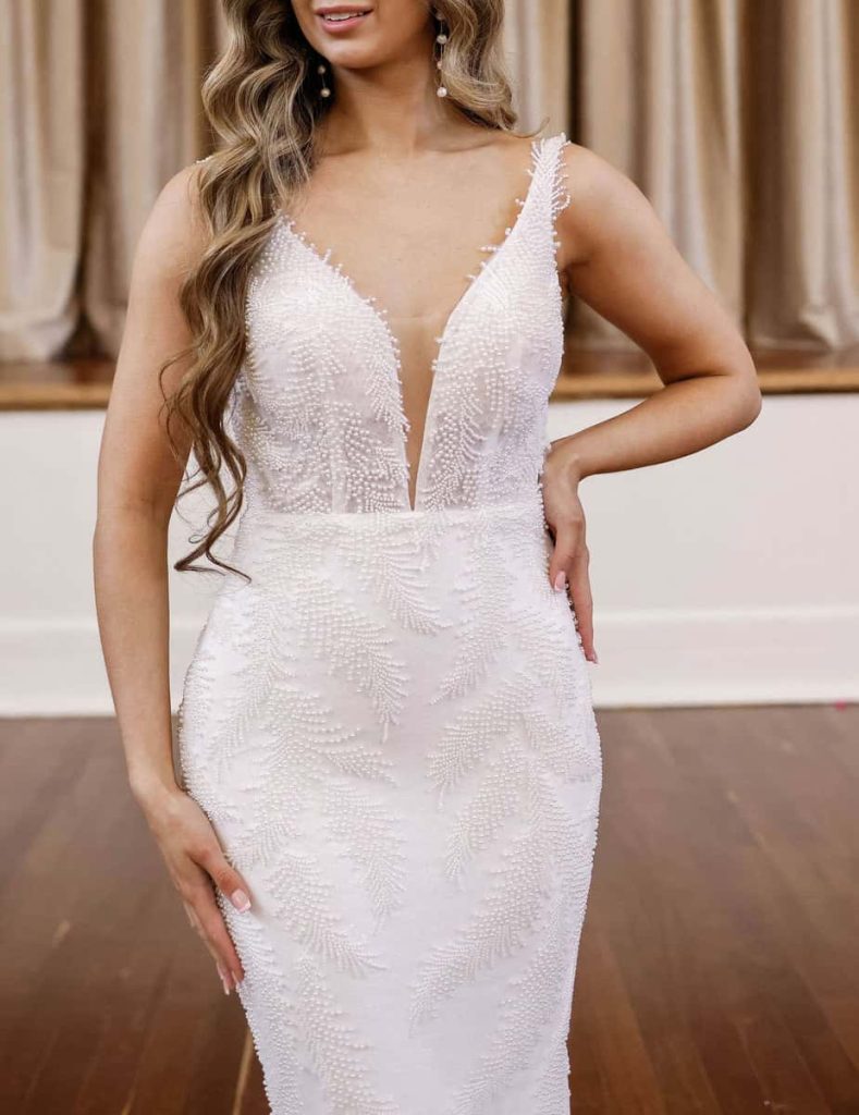 Plunging V-neck wedding dress with feather-pattern beading by Zavana Bridal