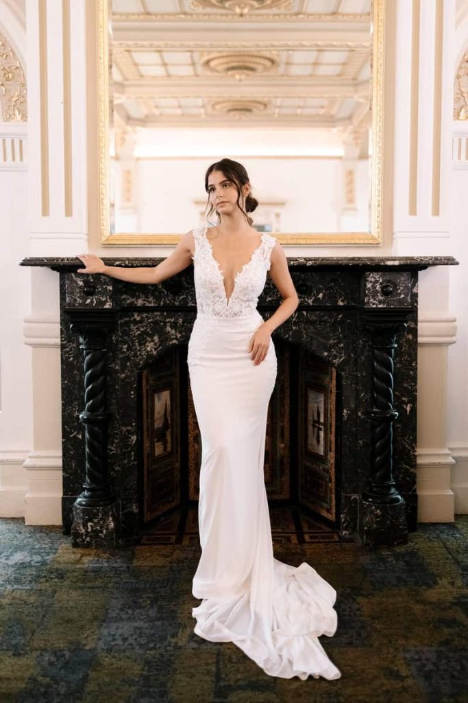 Plunging lace bodice crepe wedding gown with long train by Zavana Bridal