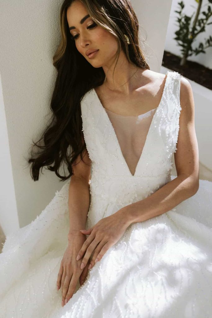 Deep V-neck beaded A-line wedding gown with sheer mesh insert by Zavana Couture